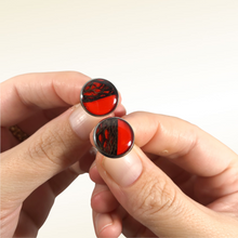 Carica l'immagine nel visualizzatore di Gallery, Orecchini a bottoncino con fibra di fico d'india sotto resina e sfondo rosso (codice R01). Base tonda anallergica nickel free in acciaio inox. Dimensione: L - 1,4 cm Ogni gioiello viene lavorato e preparato con cura; le caratteristiche della fibra naturale e della resina rendono ogni pezzo unico e irriproducibile.